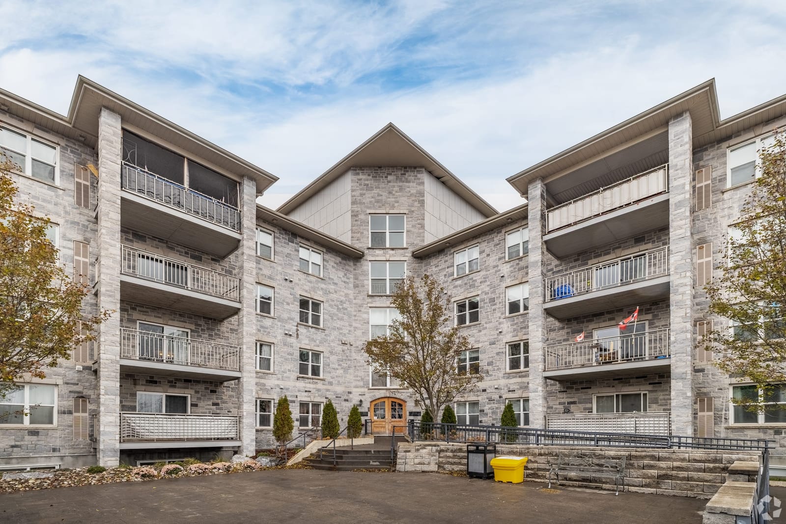 Main entrance and courtyard at 539 Armstrong Road, with the arched wooden doors and accessible ramp