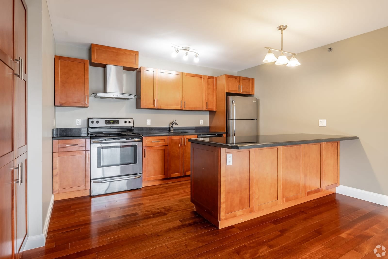 Suite kitchen with cherry cabinetry, granite island and stainless appliances