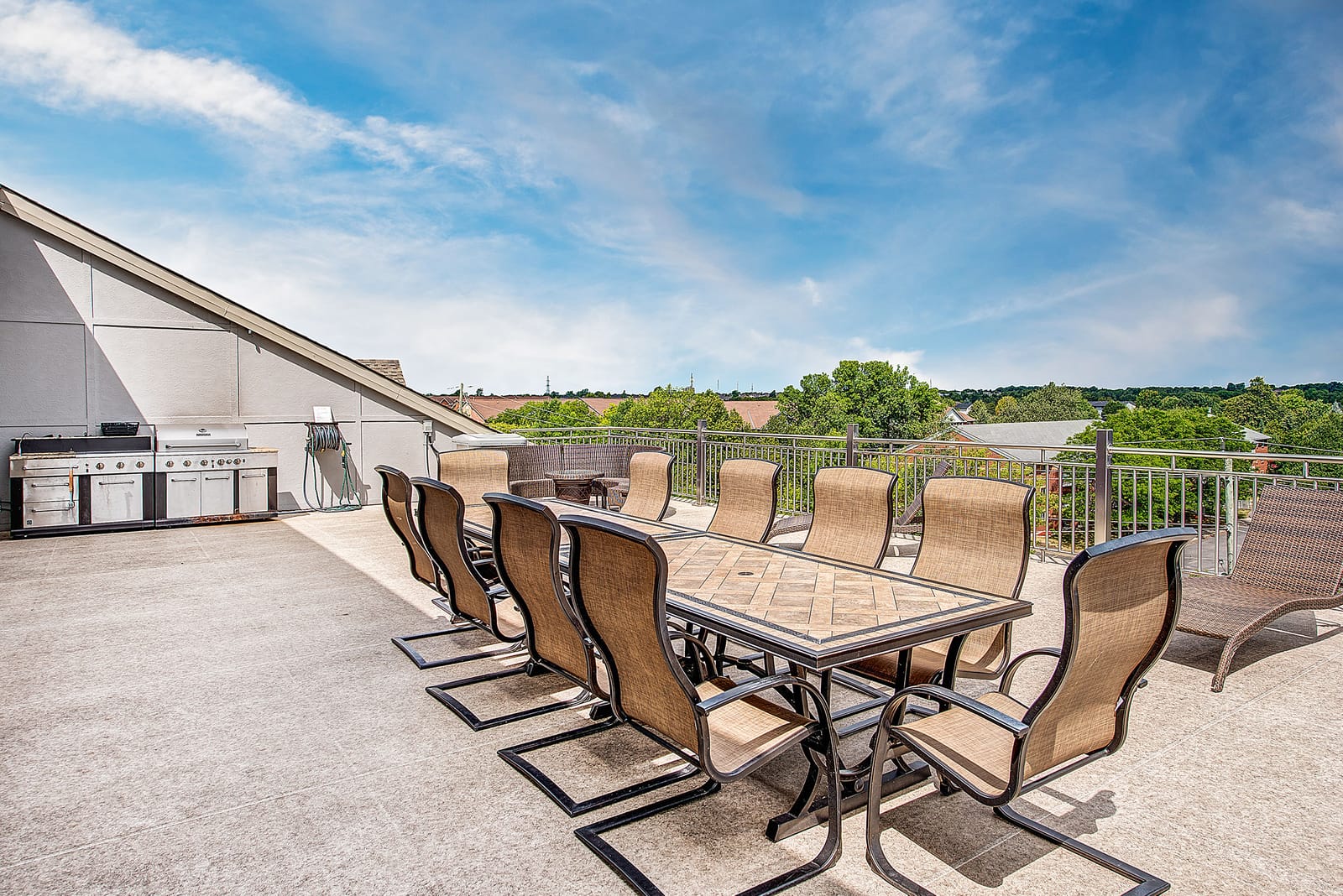 Long dining table on the rooftop terrace, beside the built-in BBQ stations