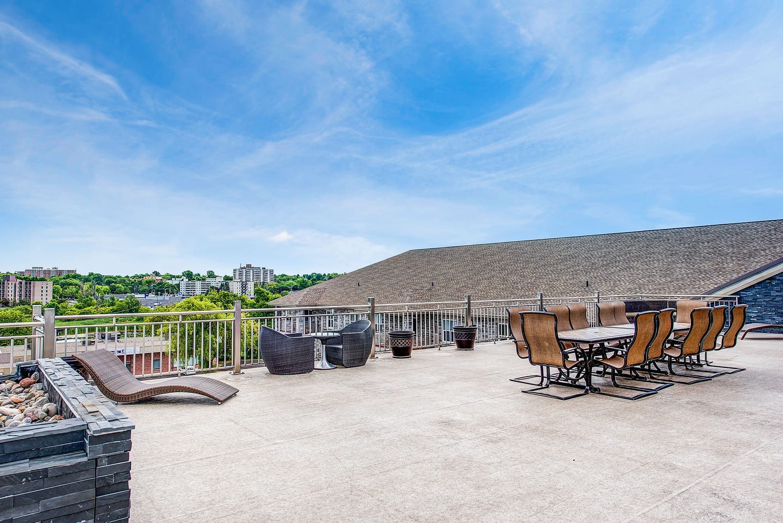 The rooftop terrace with dining sets and loungers along the railing