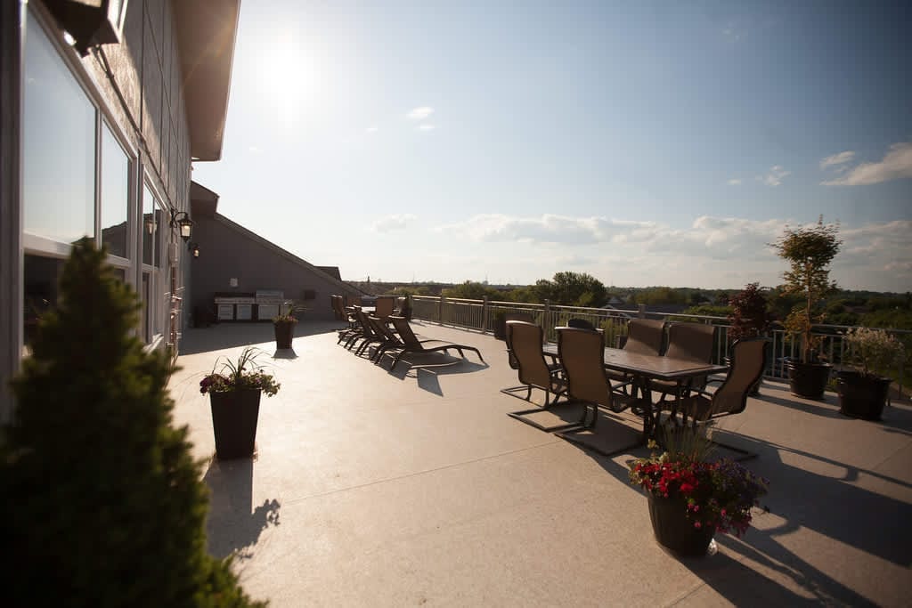Rooftop terrace with barbecue, dining table and loungers at sunset